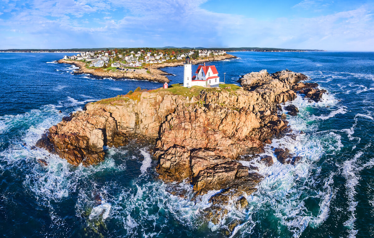 Stunning aerial panorama of lighthouse and island with crashing waves