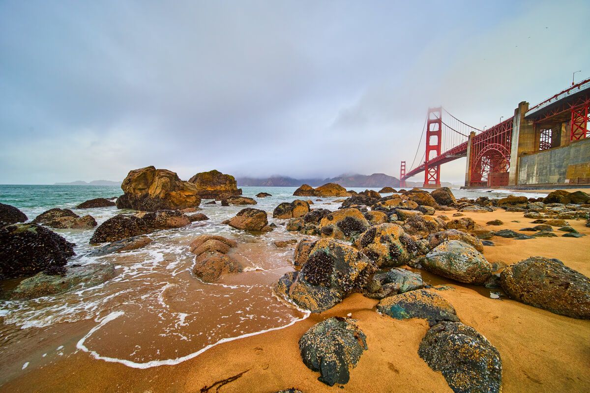 Foggy beach by Golden Gate Bridge